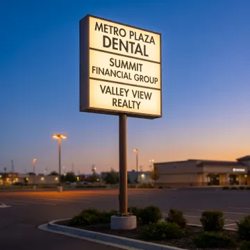 A tall, professionally installed pole sign for a local business at dusk.