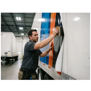 Vinyl installer applying graphics to a semi truck