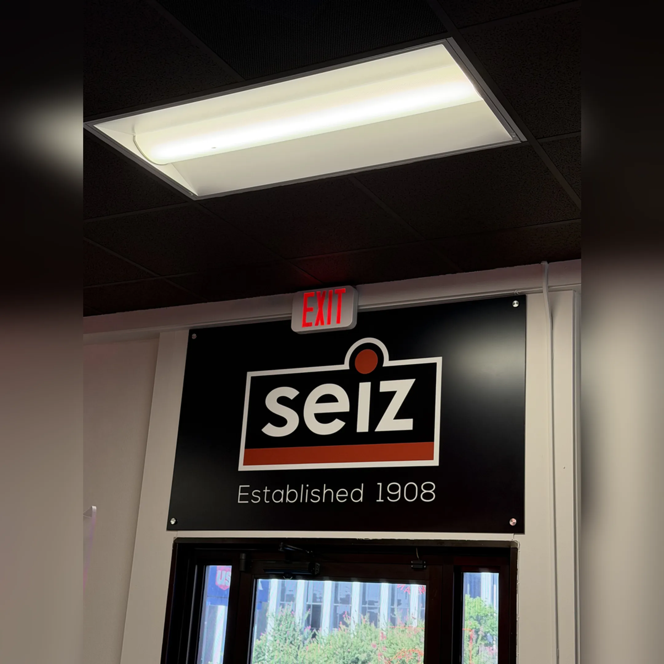 Technician repairing illuminated emergency exit sign