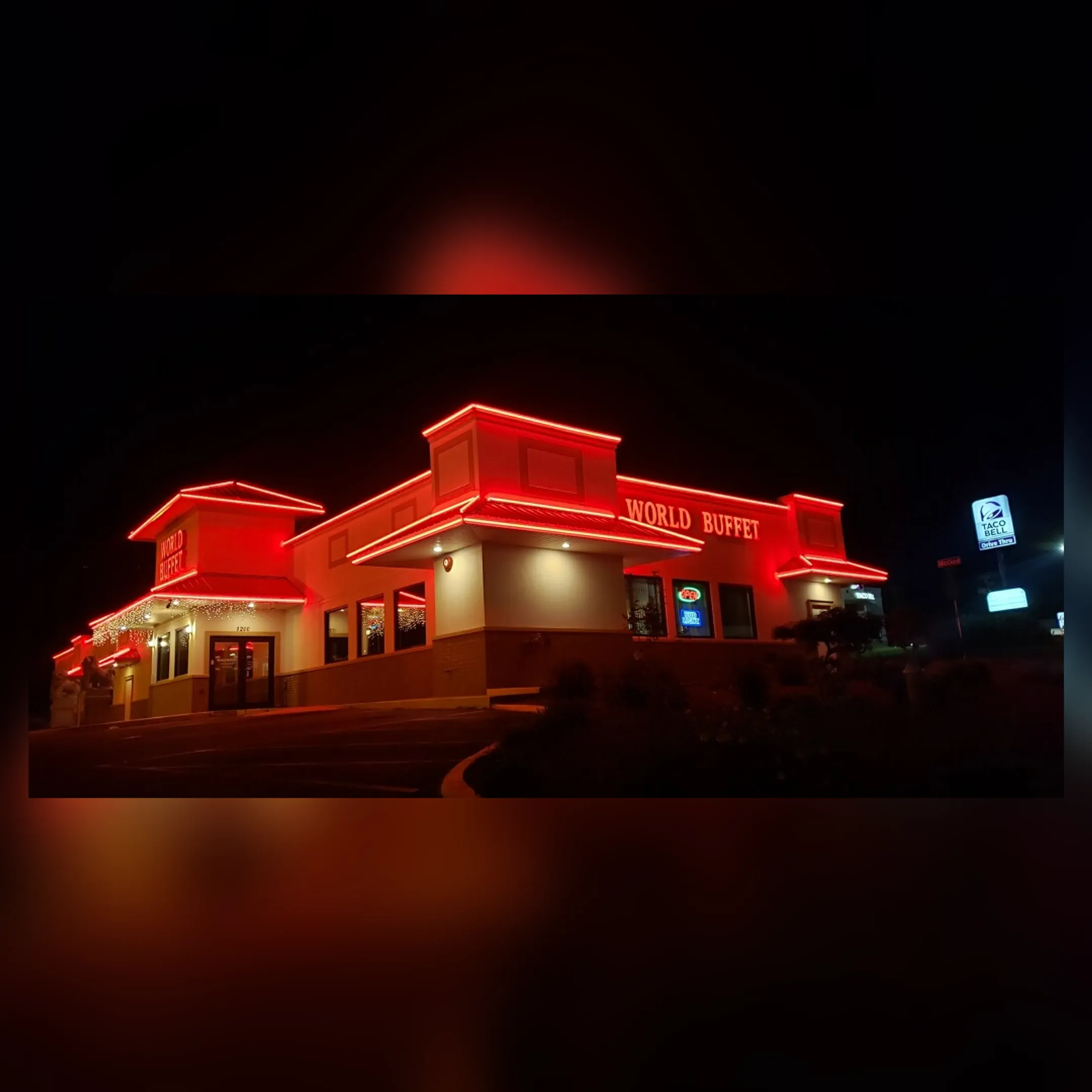A brightly illuminated and fully restored commercial business sign at night.