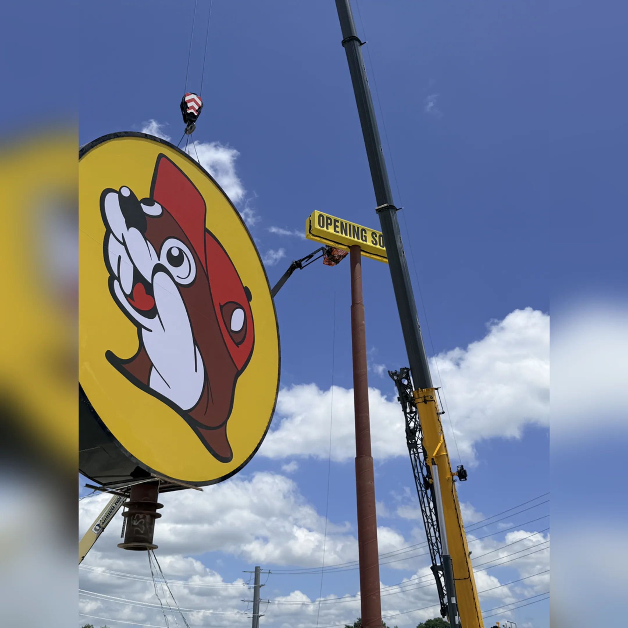 A professional technician installing a large illuminated channel letter sign on a commercial building.