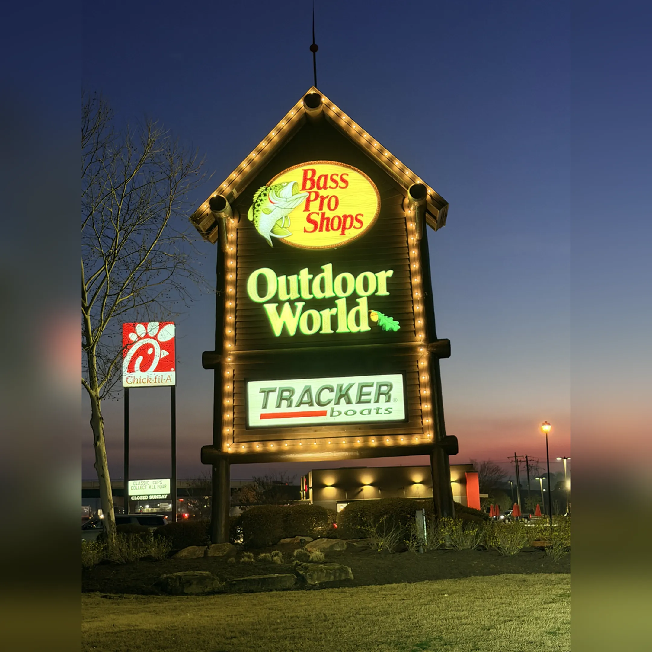 A tall, professionally installed pole sign for a local business at dusk.