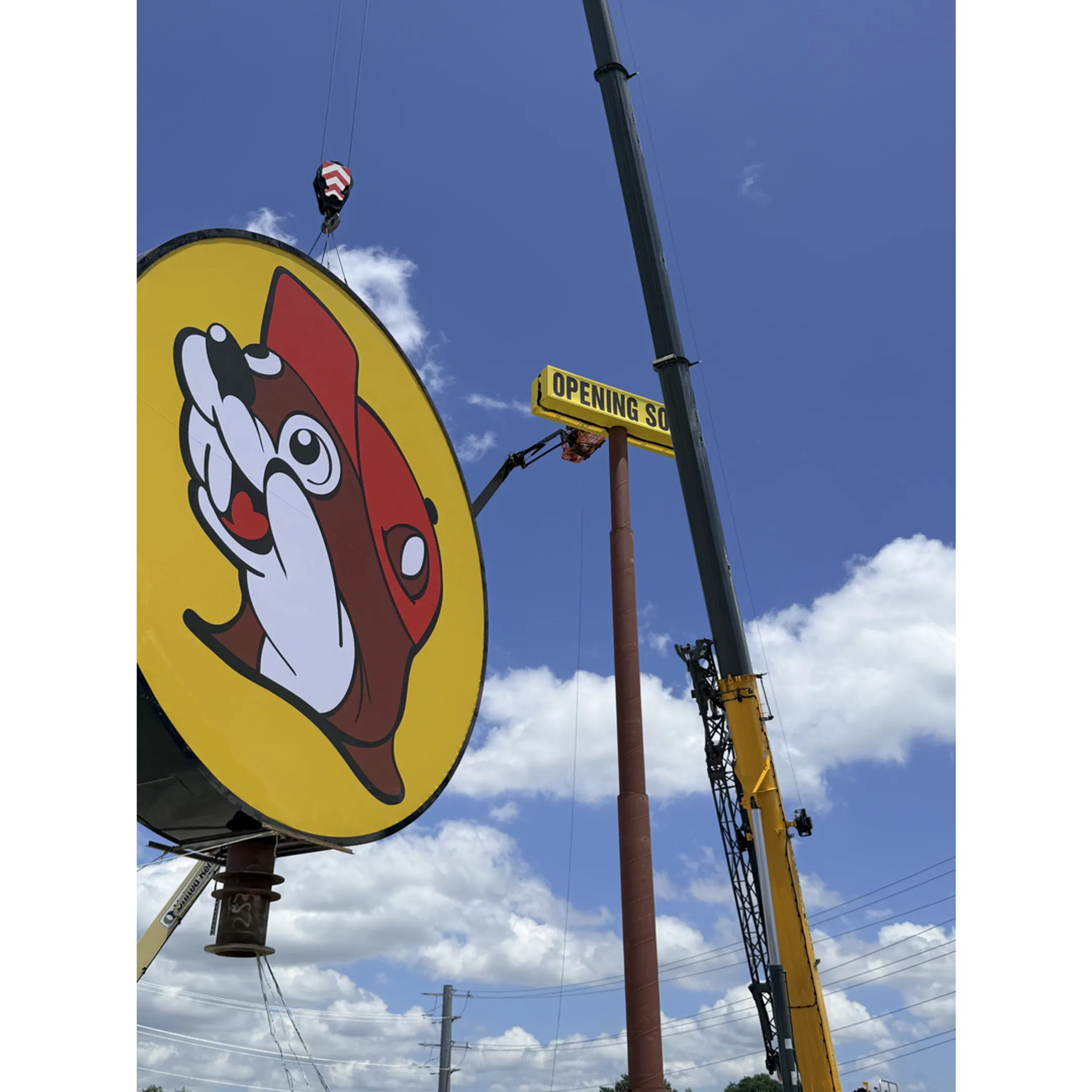 A professional technician installing a large illuminated channel letter sign on a commercial building.