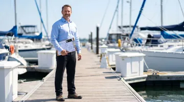 Engineer reviewing marina dock blueprints and asset classification documentation on-site