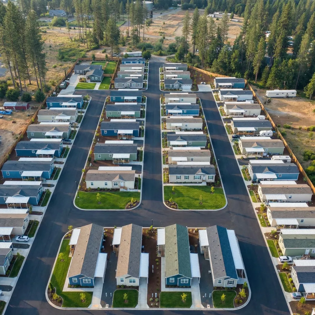 Aerial view of a mobile home park with rows of manufactured homes and paved roads