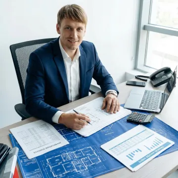 Professional engineer reviewing fixed asset depreciation schedules and property blueprints