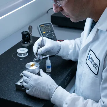 Technician installing a strain gauge on a metal test component