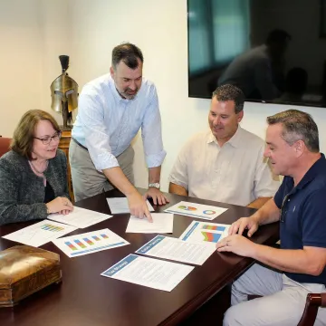 Financial advisor reviewing integrated wealth management documents with clients