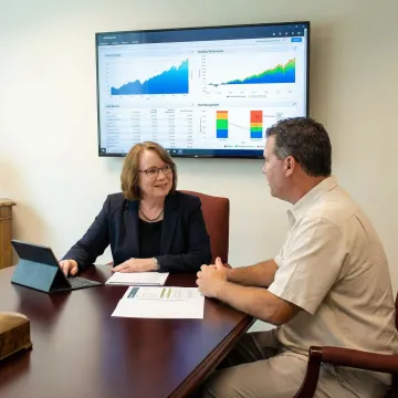 Financial advisor reviewing risk management portfolio charts with Connecticut client