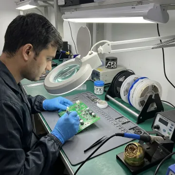 Technician assembling low volume printed circuit boards