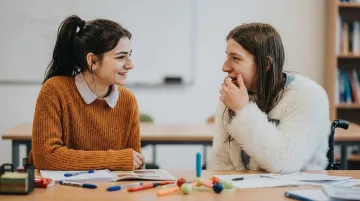 Elementary students engaged in paired discussion at classroom desks