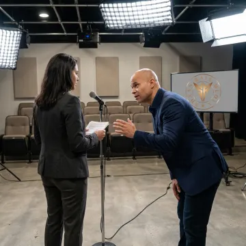 Public speaking coach guiding a business leader through presentation practice