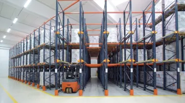Drive-in warehouse racking system with forklift entering deep storage lane