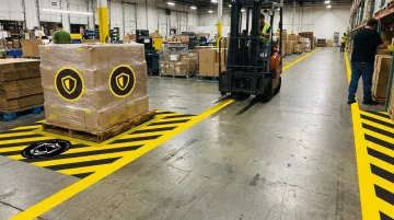 SafetyTac floor labels marking forklift lanes and hazard zones in active warehouse