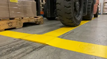 SafetyTac heavy-duty floor marking tape with beveled edges installed on warehouse floor