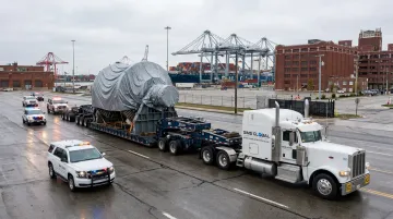 Heavy haul trucking fleet transporting oversized cargo toward port terminal