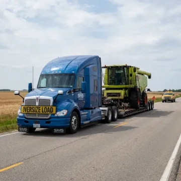 Farm equipment loaded on heavy haul trailer