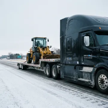 Flatbed truck hauling machinery in Minnesota