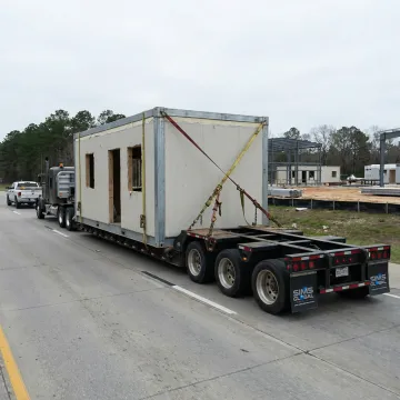 Modular building section transported on a specialized trailer
