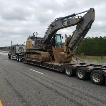 Lowboy trailer hauling heavy construction equipment
