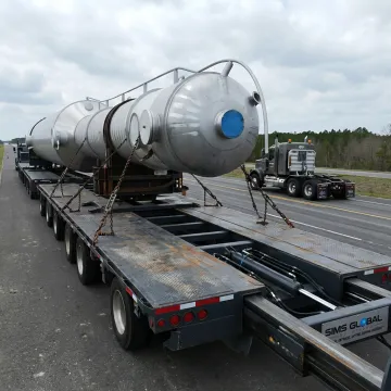 Extendable steel flatbed trailer hauling long freight