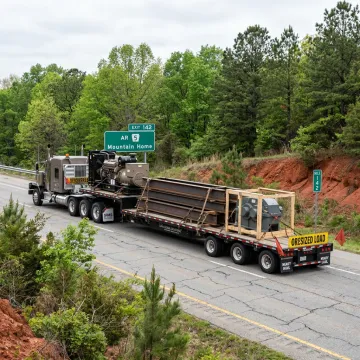 Flatbed truck hauling machinery in Arkansas