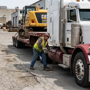 Flatbed trailer being loaded with machinery