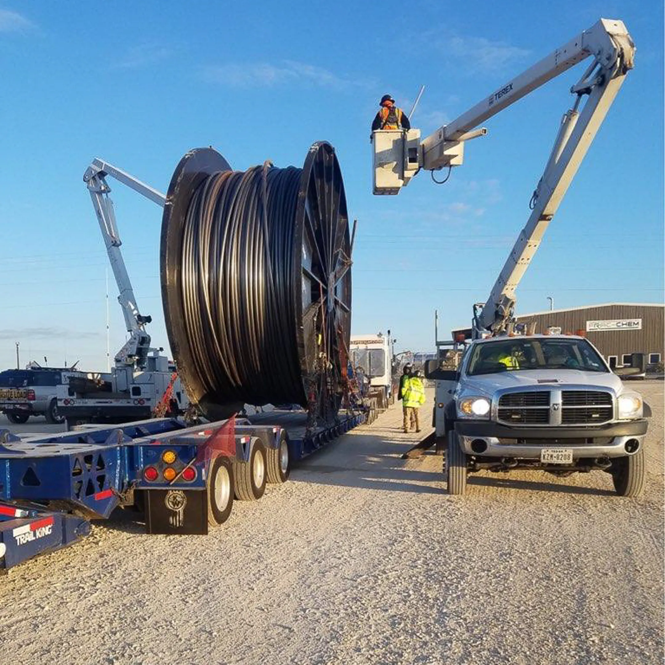Flatbed truck being loaded with heavy equipment