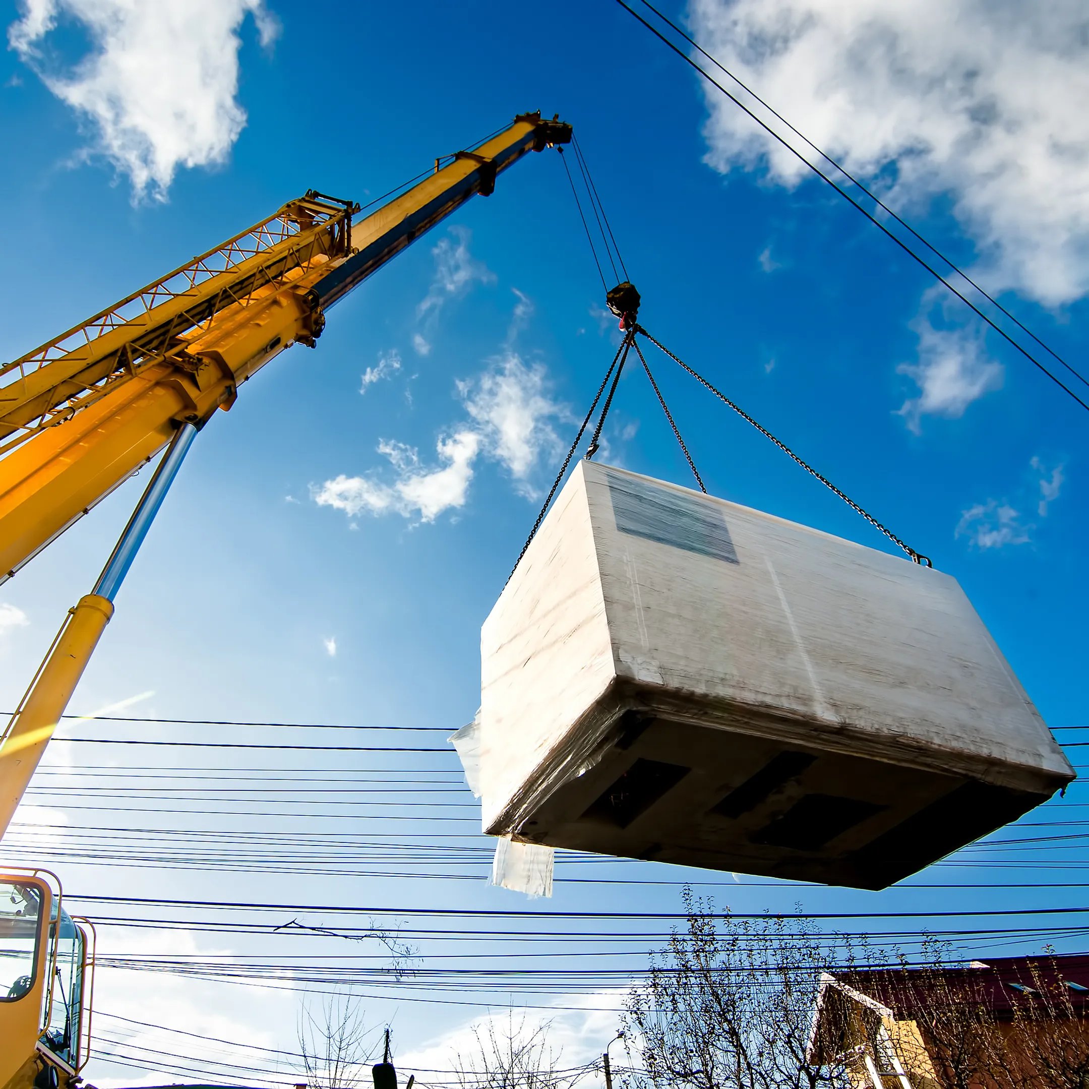 Crane lifting heavy machinery at a job site