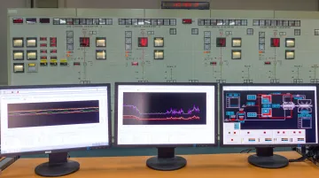 Industrial gas turbine control room with monitoring systems displaying real-time performance data