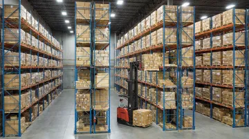 Warehouse rack system with stacked pallets and forklift operating nearby