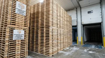 Kiln-dried heat-treated wood pallets stacked for cold storage facility use