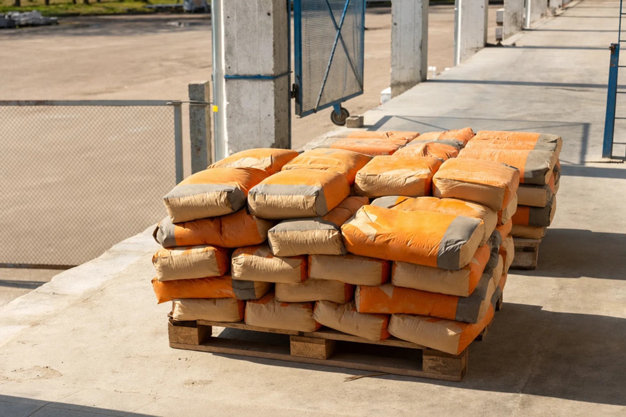 Construction materials stacked on wooden pallets elevated off ground surface