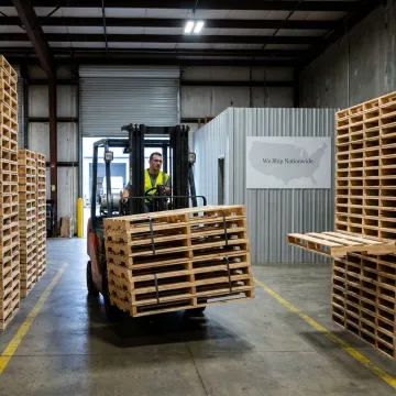 Forklift moving wood pallets