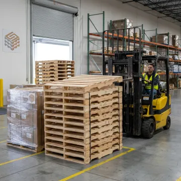 Forklift moving industrial pallets in warehouse