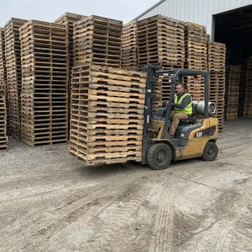 Stacks of used wood pallets ready for pickup and reuse