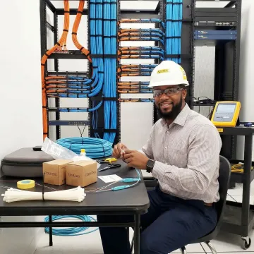 Professional fiber optic technician installing structured cabling in modern data center environment