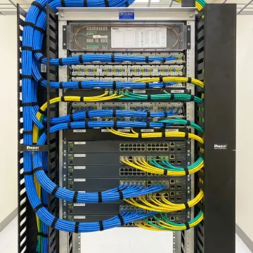 Organized office network infrastructure showing structured cabling, patch panels, and professional cable management in data closet