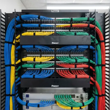 Organized network rack with labeled structured cabling and patch panels in commercial office