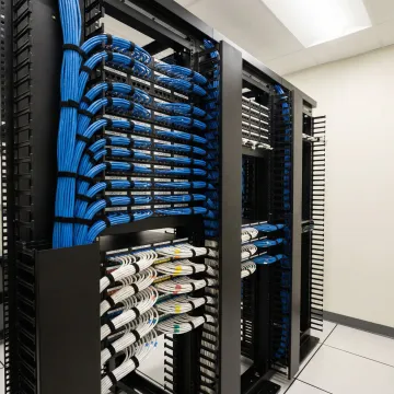 Organized network cable infrastructure with labeled patch panels in professional server room
