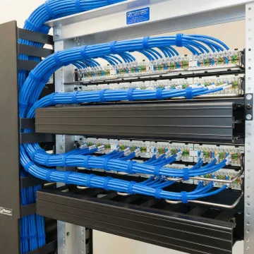 Organized network cable management system with labeled Cat6 cables and professional patch panel installation