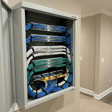 Inside view of organized Leviton structured wiring media center with labeled cables and modules
