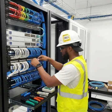 Professional technician installing structured network cabling in a modern office environment
