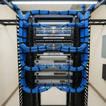 Clean telecommunications room with organized network cabling and labeled patch panels