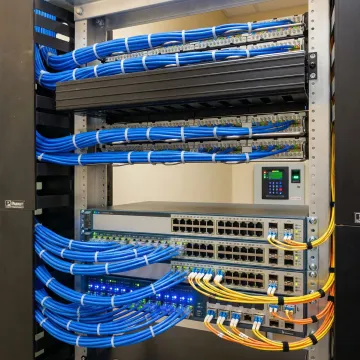 Secure network infrastructure server room with organized blue ethernet cables and mounted network switches