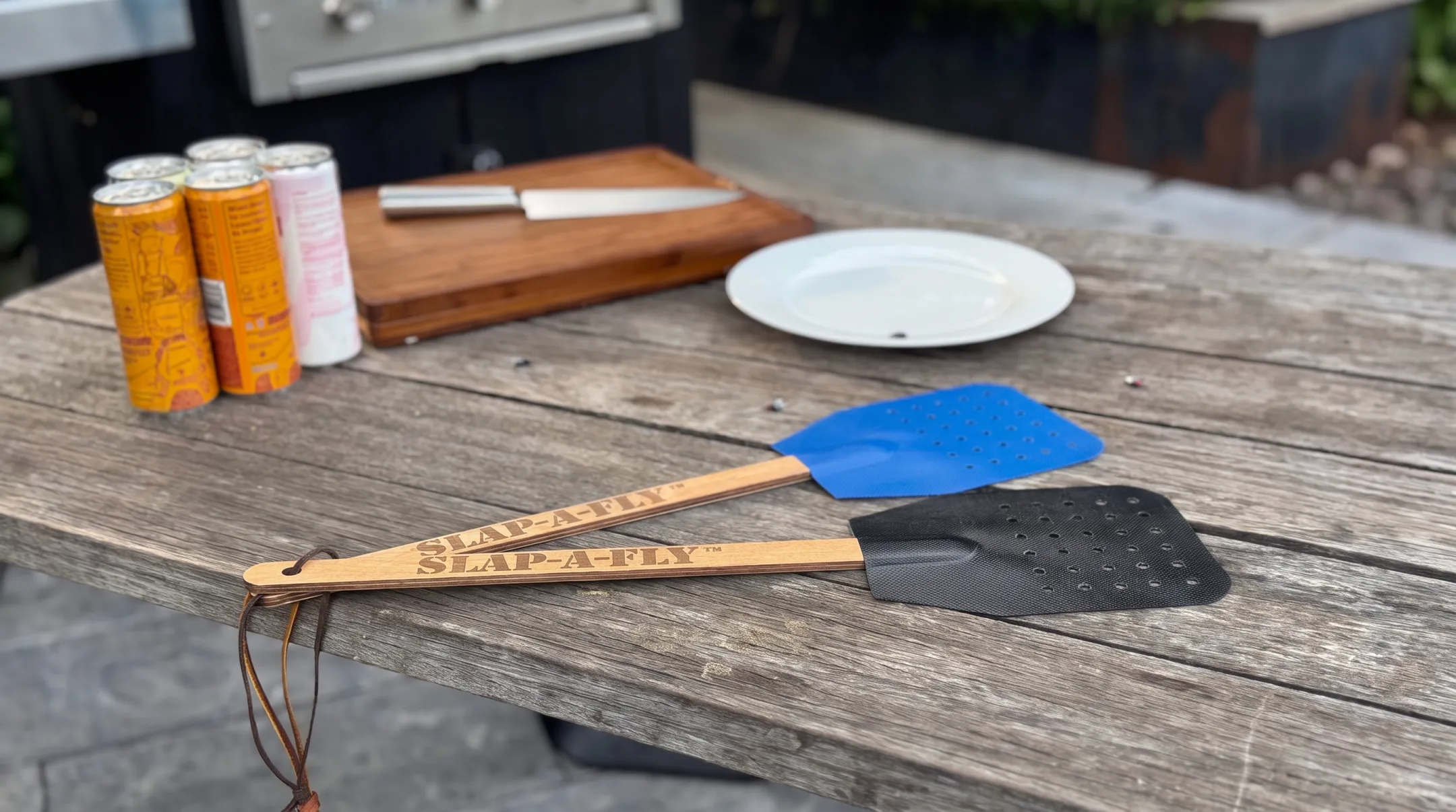 Extended-reach fly swatter with perforated Herculite fabric striking surface