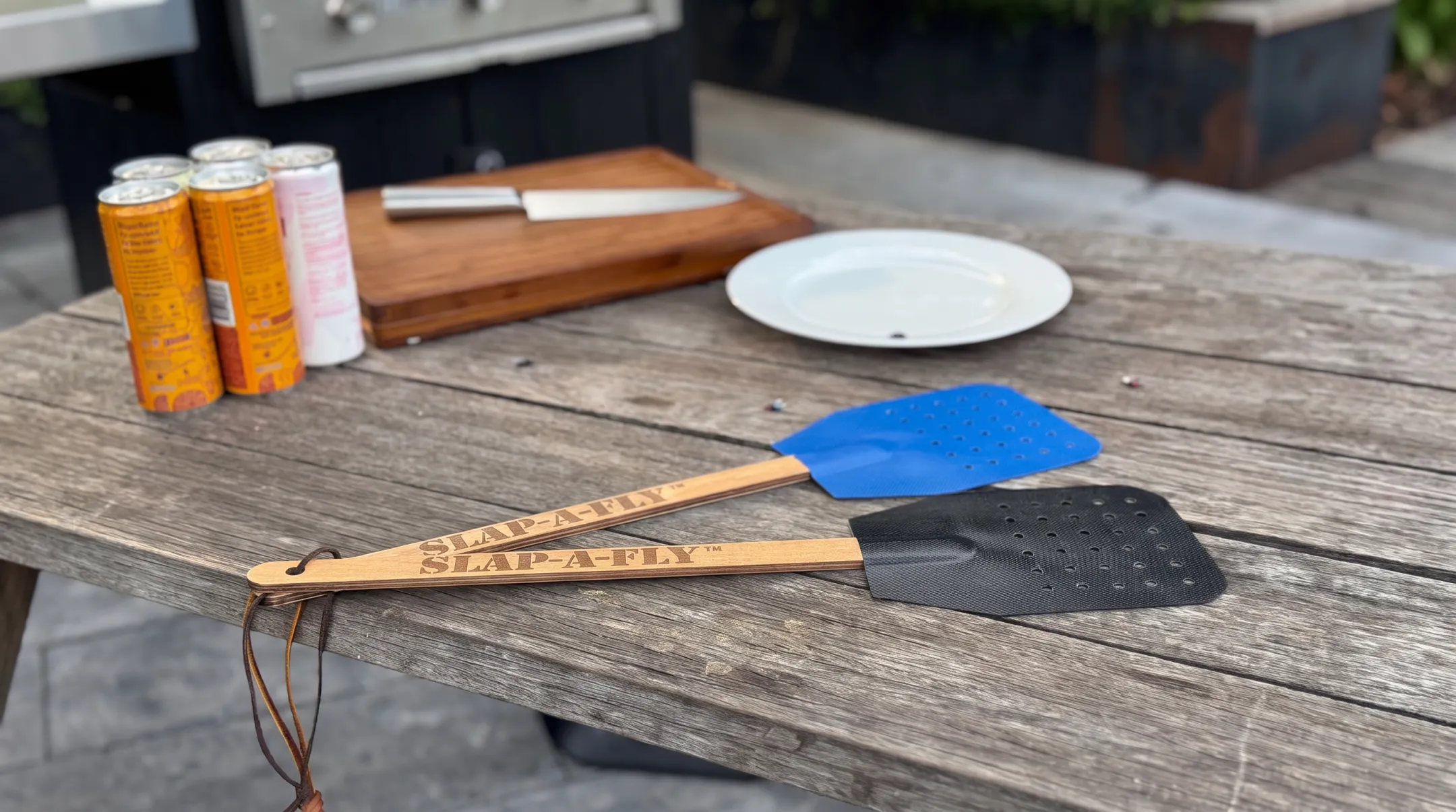 Slap-a-Fly swatter with perforated fabric striking surface and wooden handle