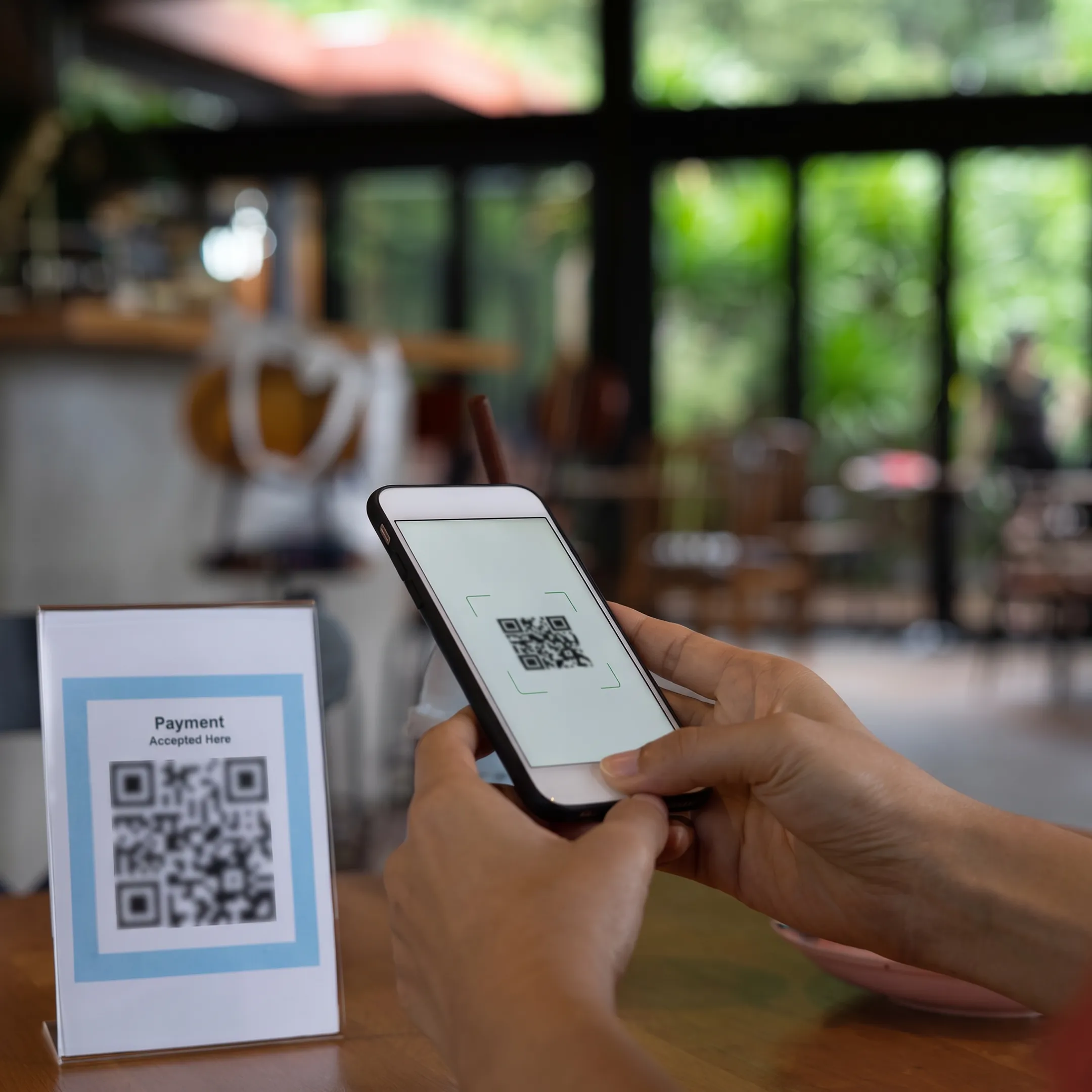 Restaurant guest scanning a QR code to order food and cocktails