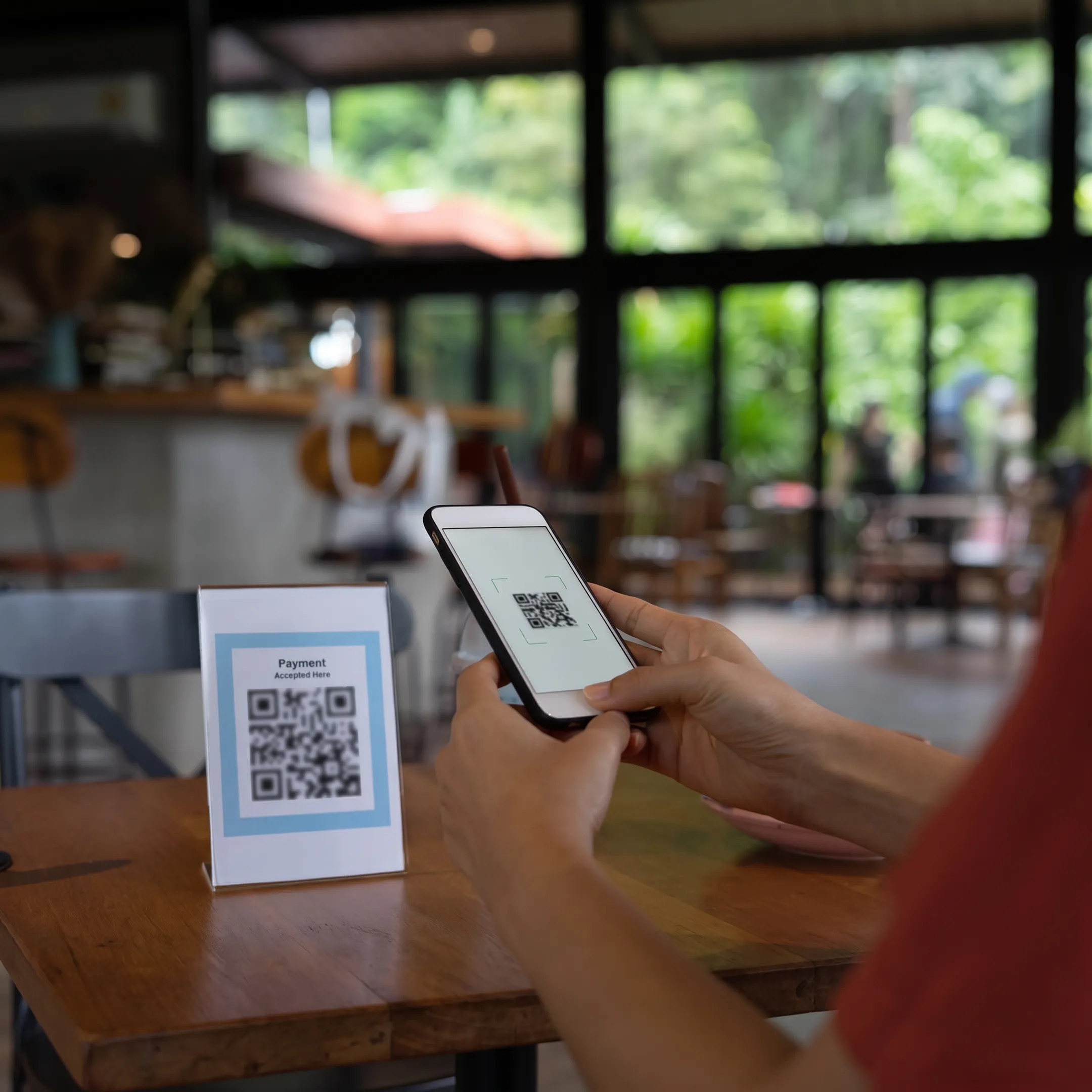 Guest using a phone to order food and cocktails at a dining venue