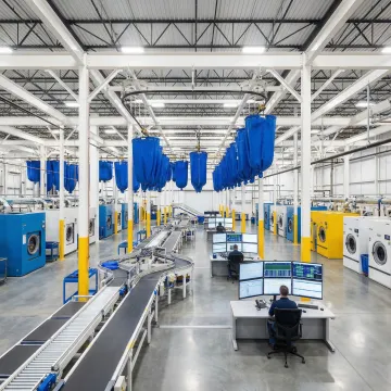 Modern automated laundry facility with robotic sorting systems and conveyor belts processing garments